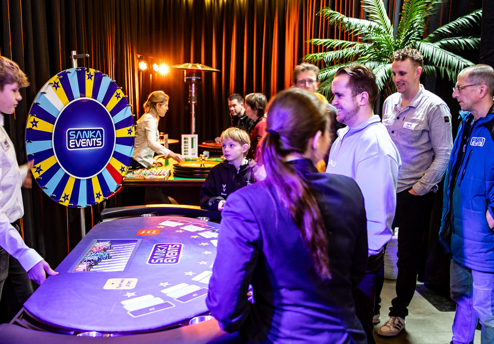 Gasten krijgen uitleg over het Wheel Of Fortune tijdens de Sanka Open Dag.
