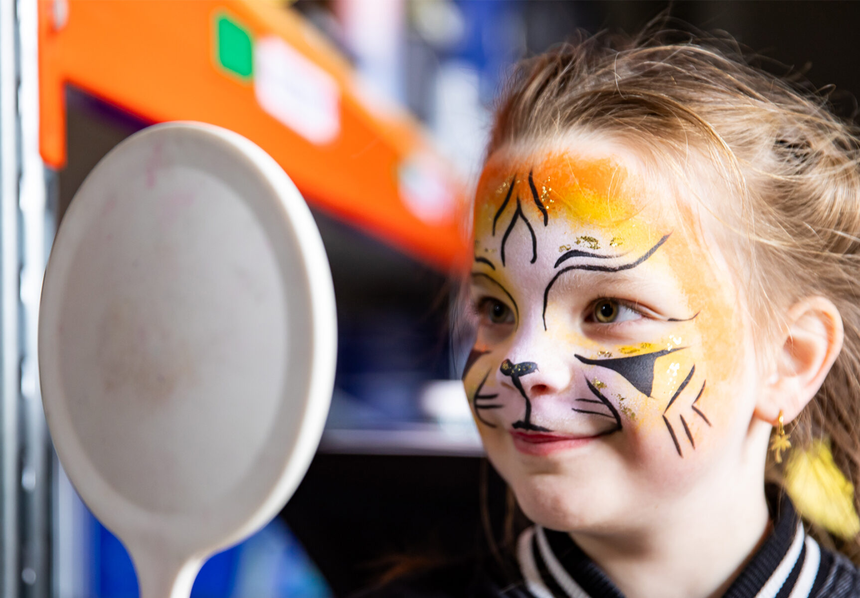 Een kind is geschminked als tijger tijdens de open dag van Sanka Events.